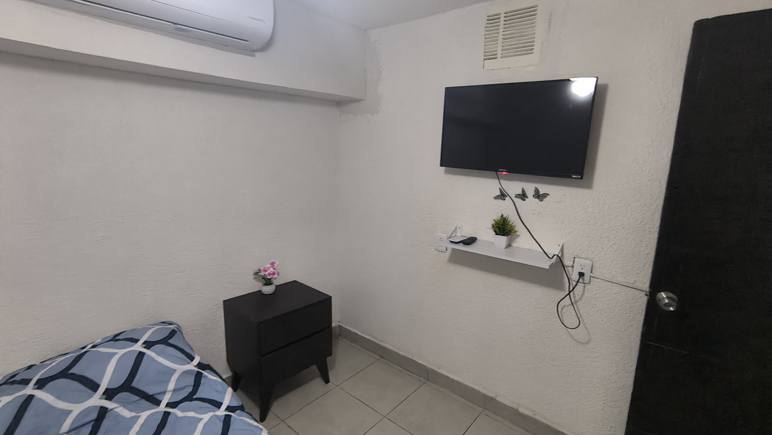 El cuarto 1 del Loft donde se ve el buró y la tele